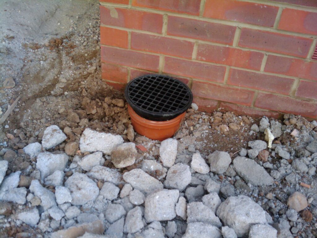 The drain, which includes a removable lid to clean rubbish out. As the garden is on a slight slope the patio will flow toward and along the house - otherwise we would have to have a wall between it and the grass.