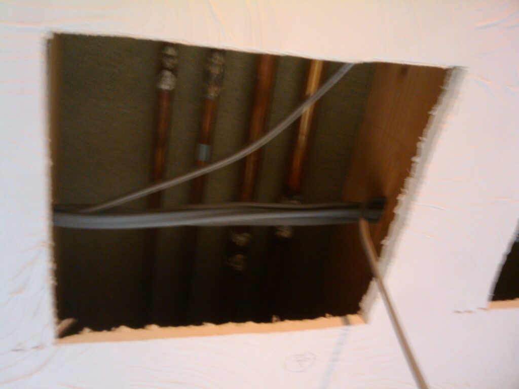 Bigger hole showing the radiator pipes too